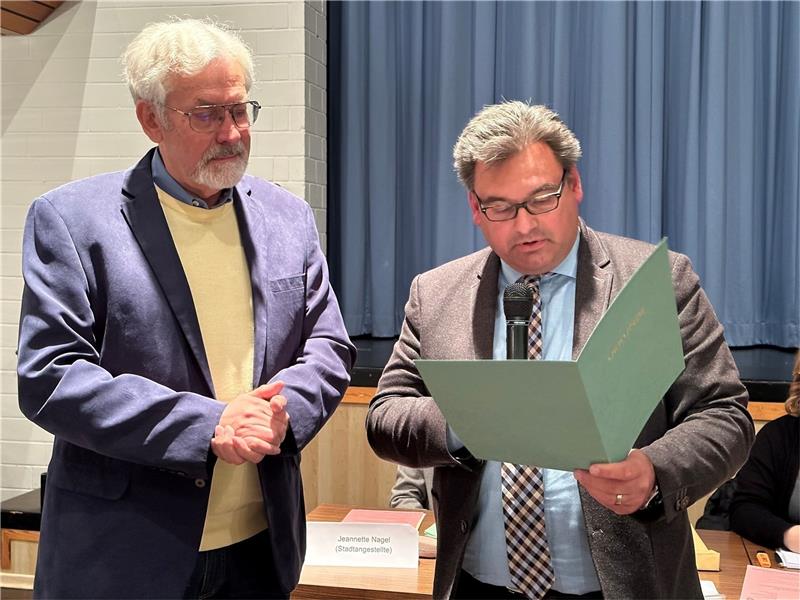 Bürgermeister Wolfgang Langer (r.) verliest die Urkunde, mit der er seinen Vorvorgänger Albert Baumann für seine 50-jährige Ratsmitgliedschaft auszeichnet. Foto: Eggers