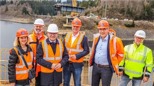 Bürgermeisterin Petra Emmerich-Kopatsch, Behördenpräsident Timo Quander, Minister Grant Hendrik Tonne, Landrat Dr. Alexander Saipa, Geschäftsbereichsleiter Günter Hartkens und Harzwasserwerke-Geschäftsführer Lars Schmidt begutachten die Baustelle an der Okertalsperre.
