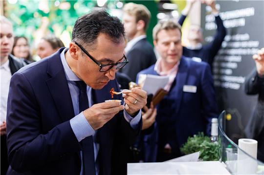Bundesagrarminister Cem Özdemir (M, Bündnis 90/Die Grünen) probiert während eines Rundgangs auf der Messe Biofach veganes Gyros.