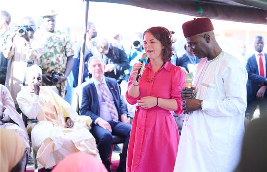 Bundesaußenministerin Annalena Baerbock spricht in Ngarannam, das 2015 von Boko Haram fast ganz zerstört und wieder aufgebaut wurde, mit Bewohnerinnen und Bewohnern.