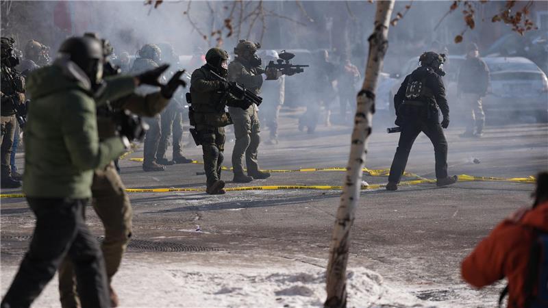 Bundesbeamte der Einwanderungsbehörde setzen nach einem Schussvorfall in Minneapolis Pfefferspray gegen Beobachter ein. 