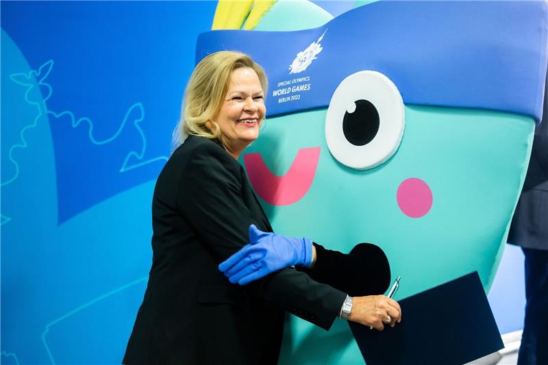 Bundesinnenminister Nancy Faeser umarmt das Maskottchen «Unity» der Special Olympics World Games.
