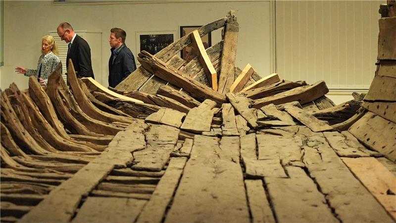 Bundeskanzler Friedrich Merz (2.v.l, CDU) geht mit Museumsdirektorin Astrid Cohrs-Dreessen (l) nach einer Pressekonferenz im Schifffahrtsmuseum Nordfriesland an dem „Zuckerschiff“ vorbei.