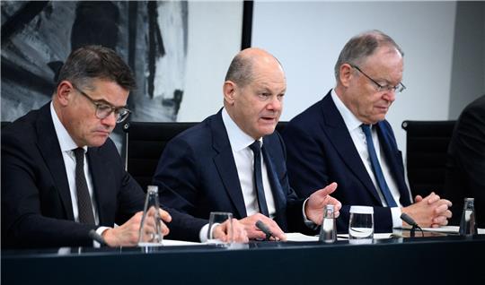 Bundeskanzler Olaf Scholz (M, SPD) äußert sich zusammen mit Boris Rhein (l, CDU), Ministerpräsident von Hessen, und Stephan Weil (SPD), Ministerpräsident von Niedersachsen, nach dem Bund-Länder-Gipfel im Bundeskanzleramt.