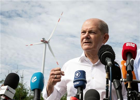 Bundeskanzler Olaf Scholz (SPD) spricht bei seinem Besuch eines Bürgerwindparks zu Journalisten.