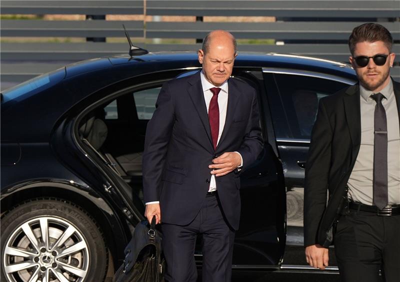 Personenschützer können nicht alles verhindern Bundeskanzler Olaf Scholz (l, SPD) kommt zum Start einer zweitägigen Reise auf dem militärischen Teil des Flughafens Berlin Brandenburg BER an und steigt aus einer Limousine.