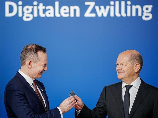 Bundeskanzler Olaf Scholz (r, SPD) übergibt an Volker Wissing (FDP), Bundesminister für Verkehr und Digitales, eine Komponente eines Schaltschranks weiter.