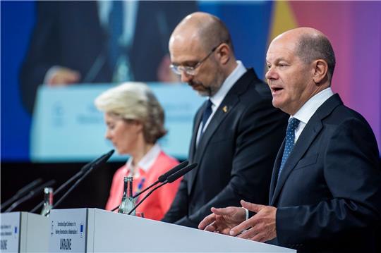 Bundeskanzler Olaf Scholz spricht bei der Expertenkonferenz in Berlin - neben ihm der  ukrainische Ministerpräsident Denys Schmyhal (M) und EU-Kommissionspräsidentin Ursula von der Leyen.