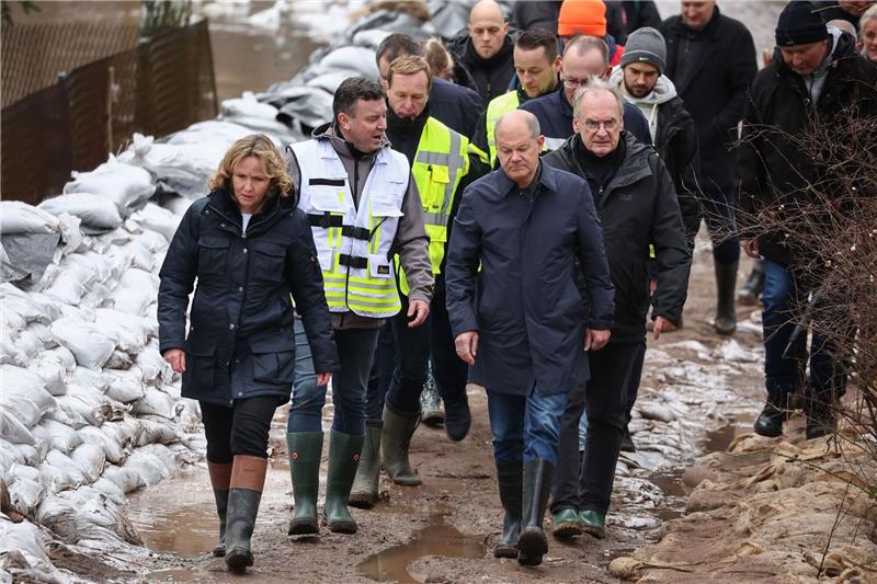 Scholz erneut im Hochwassergebiet: Kritik von Anwohnern Bundeskanzler Olaf Scholz (vorne rechts) trägt bei seinem Besuch im Hochwassergebiet in Sangerhausen Gummistiefel.