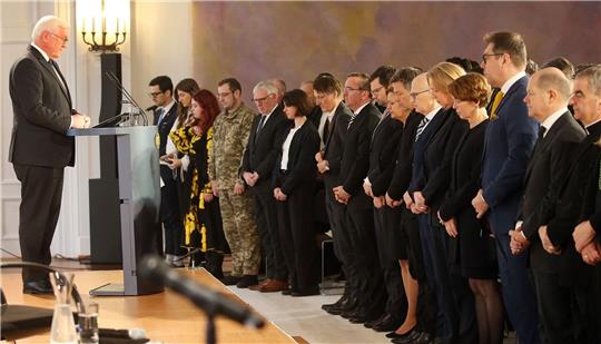 Bundespräsident Frank-Walter Steinmeier und geladene Gäste legen eine Schweigeminute ein für die Opfer des Ukraine-Krieges.
