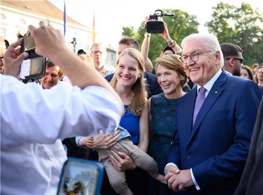 Bundespräsident Frank-Walter Steinmeier und seine Frau Elke Büdenbender lassen sich beim Bürgerfest mit Gästen fotografieren.