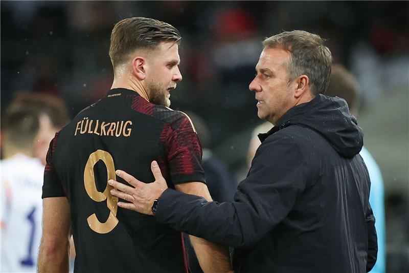 Bundestrainer Hansi Flick (r) spricht mit Deutschlands Niclas Füllkrug am Spielfeldrand.