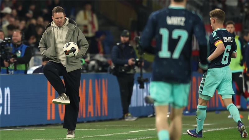 Bundestrainer Nagelsmann schießt einen Ball zurück aufs Spielfeld. 