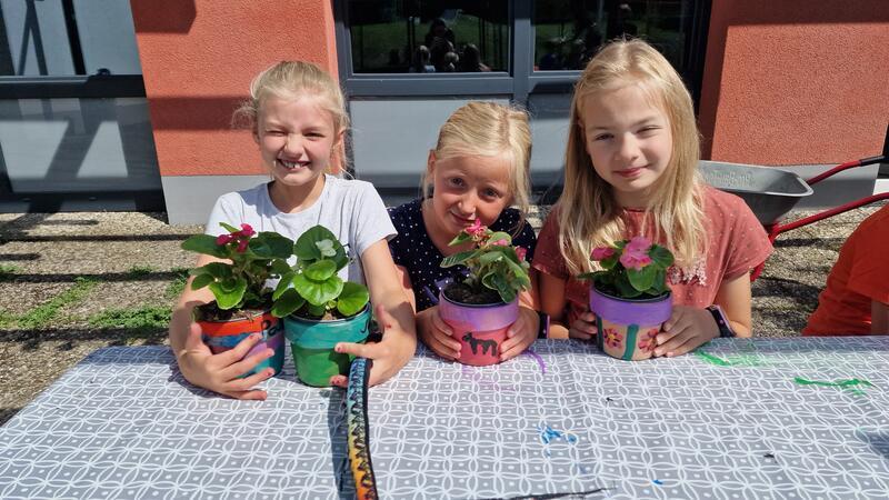 Bunt und individuell: Palina, Marie und Emma freuen sich über ihre fertigen Blumentöpfe.