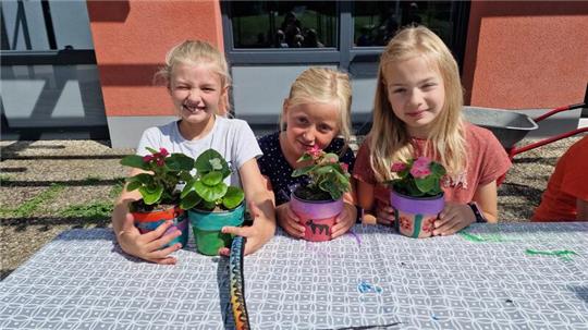 Bunt und individuell: Palina, Marie und Emma freuen sich über ihre fertigen Blumentöpfe.
