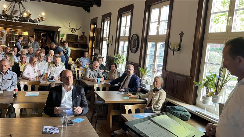 Mehrere Menschen sitzen in einem Saal.