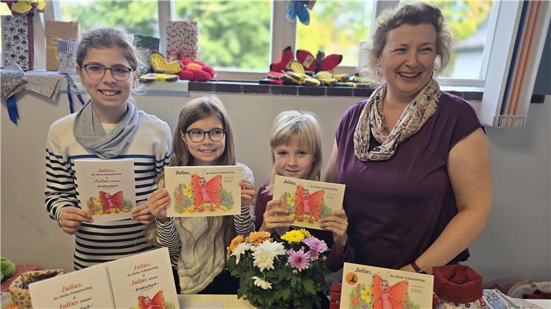 Carl (v.l.) Norea, Rosalie und Jeannette Schmöller mit ihrem Buch: „Julius, der kleine Schmetterling“.