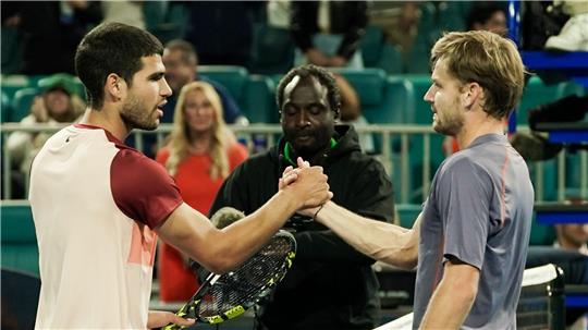 Carlos Alcaraz (l) gratuliert dem Außenseiter David Goffin für dessen Überraschungscoup.