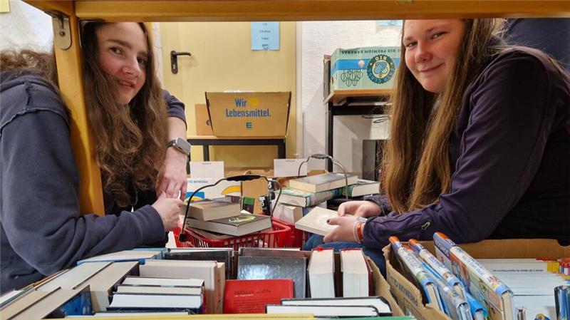 Bücherbasar in Clausthal-Zellerfeld: Schätze zum Schnäppchenpreis Caro und Nami (v.l.) stöbern auf dem Boden nach versteckten Bücherschätzen in den Kisten.