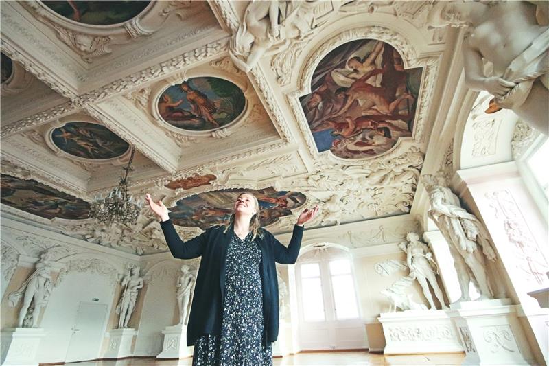 Carolin Schäfer, Chefin des Schlossmuseums, betrachtet die filigranen Deckenmalereien im Riesensaal – seinen Namen trägt der Raum wegen der überdimensionalen Figuren antiker Gottheiten an den Wänden.  Fotos: Gereke