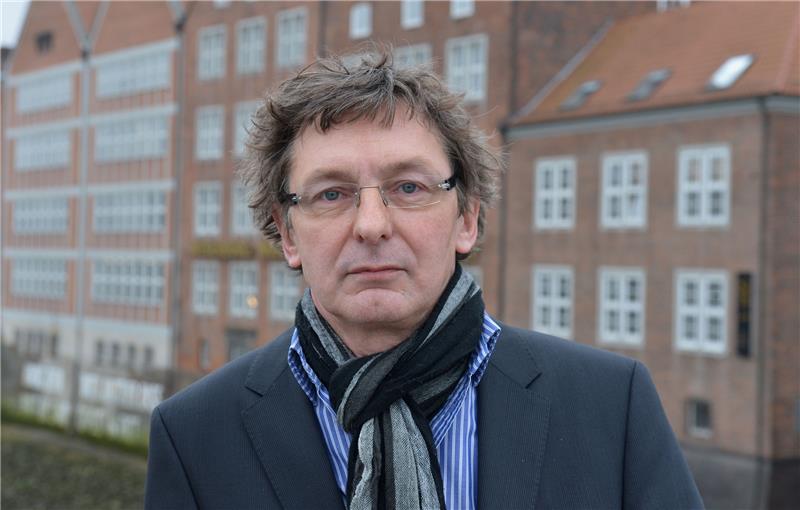 Ehemaliger Leiter des Bremer Weserburg Museums ist tot Carsten Ahrens, damaliger Direktor des Museums Weserburg (im Hintergrund zu sehen), steht auf einer Weser-Brücke. Foto: picture alliance/dpa | Carmen Jaspersen