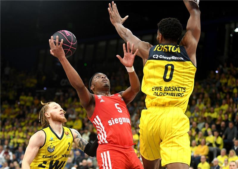 Bayern-Basketballer holen Pokal - „Nimmt uns Druck” Cassius Winston (M) vom FC Bayern kommt gegen Oldenburgs Hassani Gravett (l) und Shakur Juiston zum Wurf.