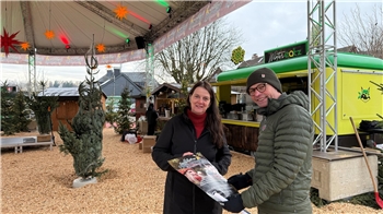 Eine Frau und ein Mann blicken auf dem überdachten Platz Neue Mitte in die Kamera.