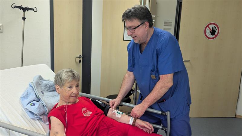 Chefarzt Dr. Jürgen Kluth legt einer Frau eine Infusion.