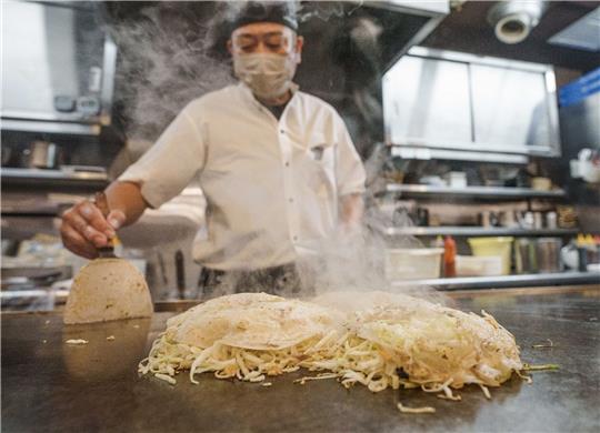 Chefkoch Mitsuo Ise hat für das Gericht «Okonomiyaki», eine Art japanische Pizza, eine spezielle «Deutschland»-Version für Bundeskanzler Scholz mit den Zutaten Würstchen, Kartoffeln und Sauerkraut kreiert.