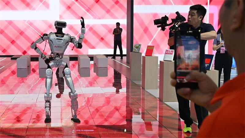 China: Besucher verfolgen auf der 26. Investitions- und Handelsmesse die Vorführung eines Roboters