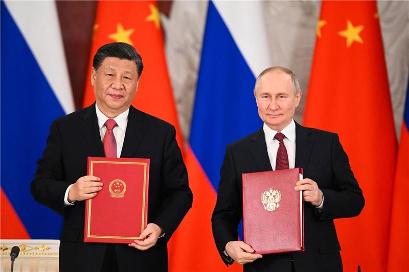 Xi Jinping beendet Staatsbesuch in Moskau Chinas Präsident Xi Jinping und sein russischer Amtskollege Wladimir Putin zeigen während einer Unterzeichnungszeremonie Mappen mit den neuen Abkommen.
