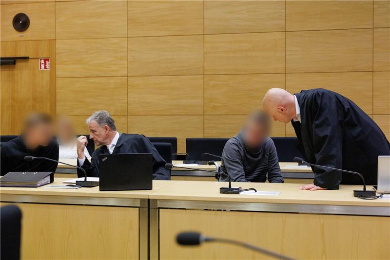 Tödliche „Spaßfahrt” - Bewährungsstrafe für Motorradfahrer Christian Thüner (2.v.l) und Jerrit Schöll (r), die Verteidiger der Angeklagten, sprechen mit ihren Mandanten in einem Saal des Landgericht Bielefeld zum Auftakt im Prozess um ein illegales Motorradrennen mit Todesfolge.