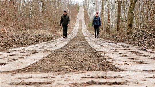 Zwei Personen spazieren auf einem alten DDR-Kolonnenweg.