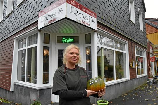 Claudia Warnecke vor ihrem Café und Restaurant. In der Hand hält sie ein Abschiedsgeschenk von Kunden, einen Kürbis. Foto: Berg
