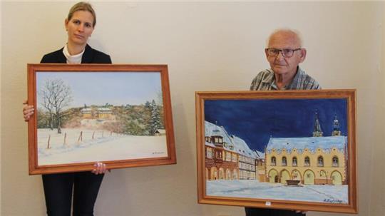 Cordula Wulf und Horst Kintscher präsentieren zwei Landschaftsbilder: das Schloss Liebenburg und den Goslarer Marktplatz.