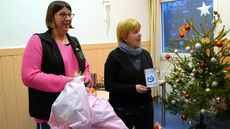Tourist-Information lässt im Oberharz Wünsche wahr werden Corinna Schmottlach von der Tourist-Information (l.) erhält vom Haus Wiesengrund zum Dank gleich zwei Blumensträuße. Fachkraft Ina Köppen zählt indes das Geld aus der Spendendose aus.
