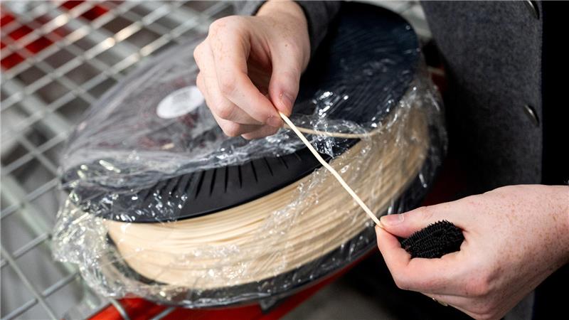 Cornelius Schmitt, CEO vom Schuhhersteller Zellerfeld, zeigt einen Faden von einer Kunststoffrolle zur Herstellung von Schuhen aus dem 3D-Drucker.