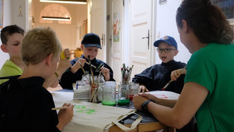 In Bad Harzburg sind Kreativität und Spontanität gefragt Da das Rausgehen aufgrund des Wetters nicht möglich ist, gestalten die Kinder Jutebeutel.