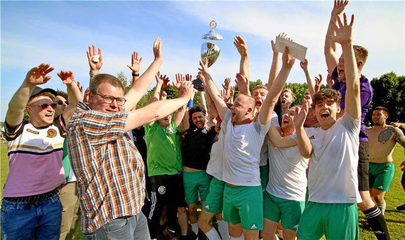 Pokal-Endspiele bleiben ein Erfolgsmodell Da hebt sogar der Deckel ab: GZ-Mitarbeiter Malte Thielemann (li.) übergibt den Pokal der Goslarschen Zeitung für den Sieger im Pokal der 2. Nordharzklassen an einen überglücklichen VfB Dörnten. Foto: Epping