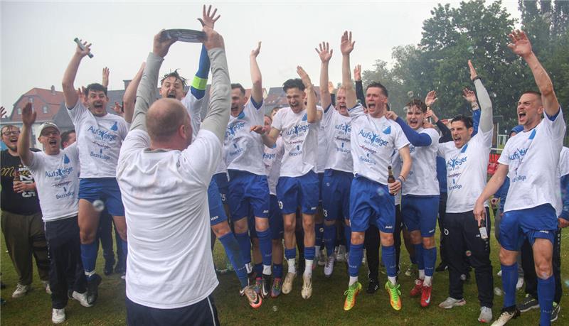 Da ist das Ding: Der scheidende Trainer Dennis Gläser präsentiert den Spielern der FG Vienenburg/Wiedelah nach dem 7:1 gegen Rhüden die Meisterschale. Foto: Gietemann