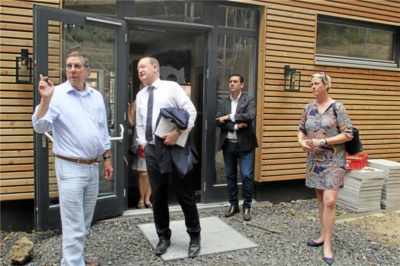 „Da oben kommen die Baumhäuser hin“ – am Hintereingang des „Hexenwerks“ zeigt Investor Thomas Funke Finanzminister Reinhold Hilbers im Beisein von Resort-Gastgeber Ayhan Soljin und Pächterin Karina-Anna Dörschel (v.li.) das, was auf dem kleinen Bild gerade entsteht: das Doppel-Baumhaus „Elvis“ am Hang. Fotos: Breuer