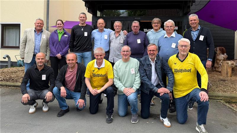Gruppenfoto von 14 Personen vor einem Gebäude. 