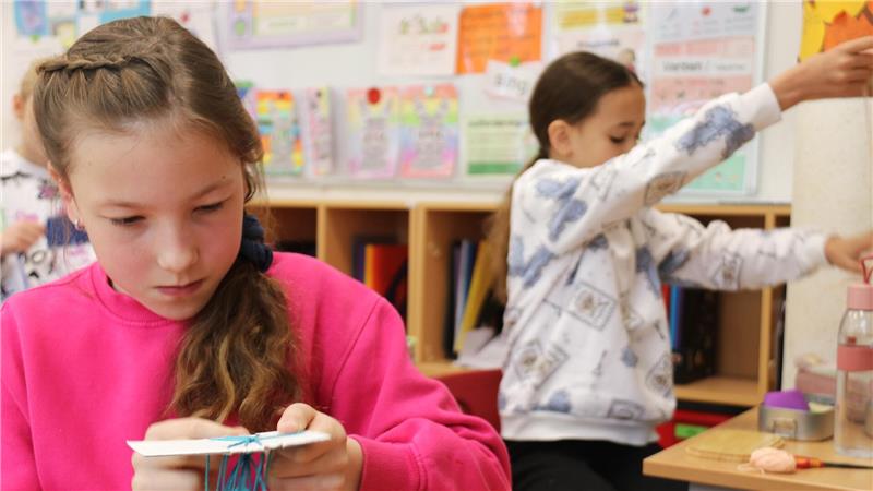 Damit die Freundschaft für immer hält: Amelie (l.) knüpft ein Freundschaftsarmband an der Grundschule Worth.