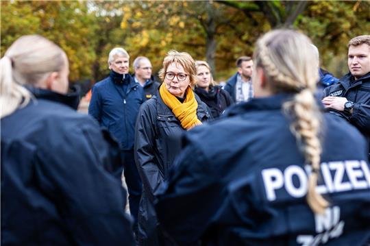 Daniela Behrens (SPD, M), Innenministerin von Niedersachsen, spricht mit Einsatzkräften der Polizei vor dem Stadion.