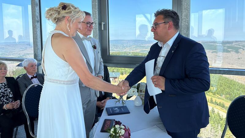 Braunlages Bürgermeister traut sein erstes Hochzeitspaar Darauf der förmliche Händedruck: Bürgermeister Wolfgang Langer (rechts) traut nach dem Standesamt-Seminar als erstes Paar seine guten Freunde Stephen Buchholz und Eileen Buchholz, geborene Makus, auf dem Wurmberg.
