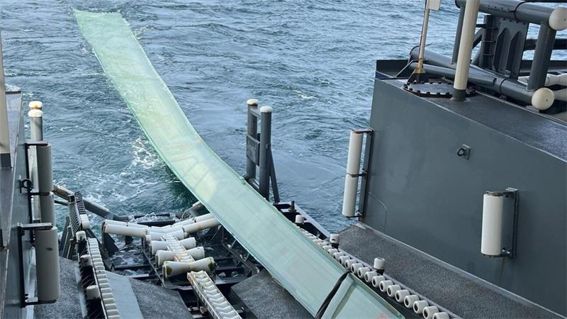 Das 20 Meter lange Rotorblatt wird über die Heckwanne an Bord gezogen.