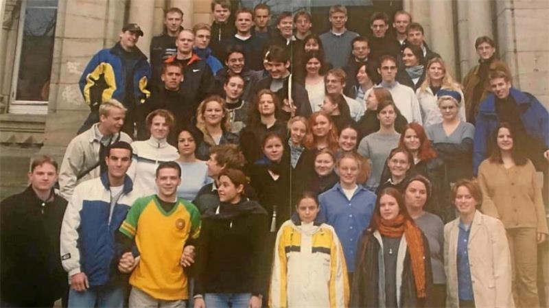 Gruppenfoto von jungen Erwachsenen auf einer Treppe vor einem Gebäude