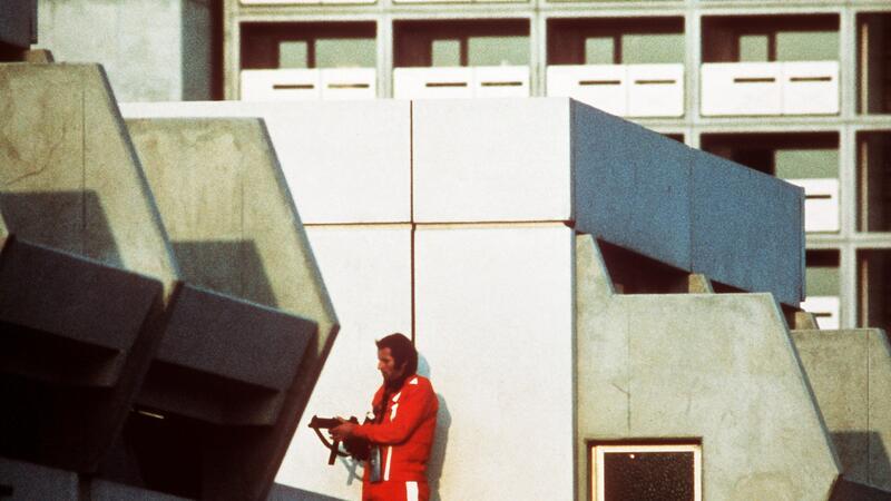 Das Archivbild vom 5. September 1972 zeigt einen bewaffneten Polizeibeamten im Trainingsanzug, der den Block im Olympischen Dorf in München abschirmt, in dem Terroristen israelische Sportler der Sommerspiele festhielten.