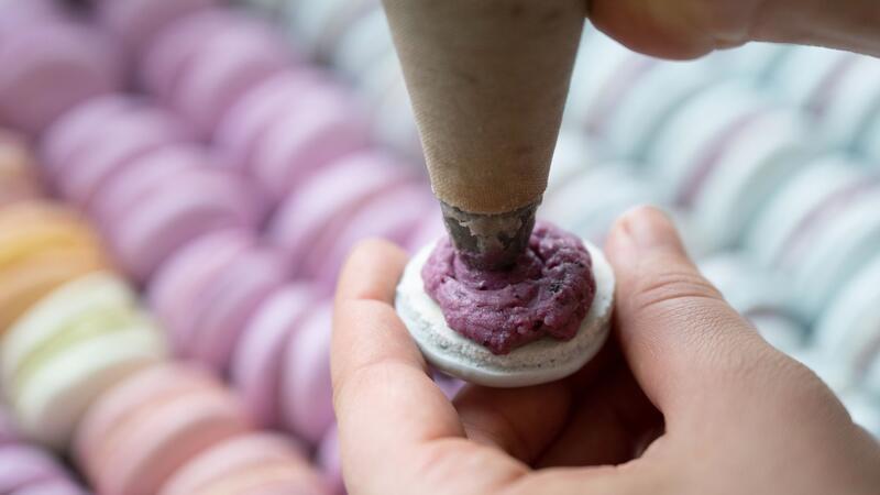 Macarons und Co: Tschüs Nachtisch, Hallo Luxusdessert Das Baisergebäck Macaron wird in einer Bäckerei mit einer Spritztüte befüllt. (Archivbild)