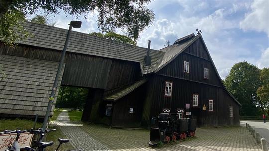 Das Foto zeigt ein Gebäude mit einer alten Förderbahn davor.
